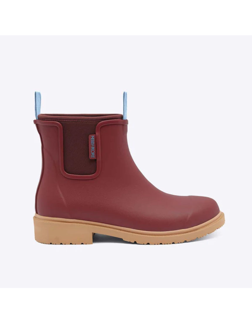 Brick red Merry People Bobbi gumboots shown from the side, featuring waterproof rubber and stylish design for rainy weather.