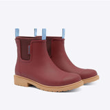 Brick red Merry People Bobbi gumboots with black sole and rounded toe, stylish waterproof footwear for rainy days.