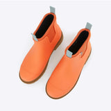 Merry People Bobbi gumboots in Sherbet Orange, high-angle view showing waterproof rubber footwear with textured sole.