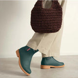 Merry People Bobbi Gumboots in teal worn by a model, featuring waterproof rubber design and stylish, vibrant teal color.
