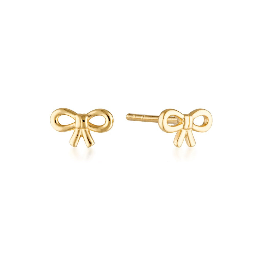 Linda Tahija bow stud earrings featuring gold-tone metal and small bow design, close-up view of the jewelry.
