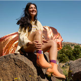 Merry People Bobbi gumboots in vibrant sherbet orange, showcasing a stylish waterproof footwear design for rainy days.