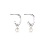 Linda Tahija Pearl Charm Hoop Earrings featuring gold hoops with dangling pearl charms and intricate detailing.
