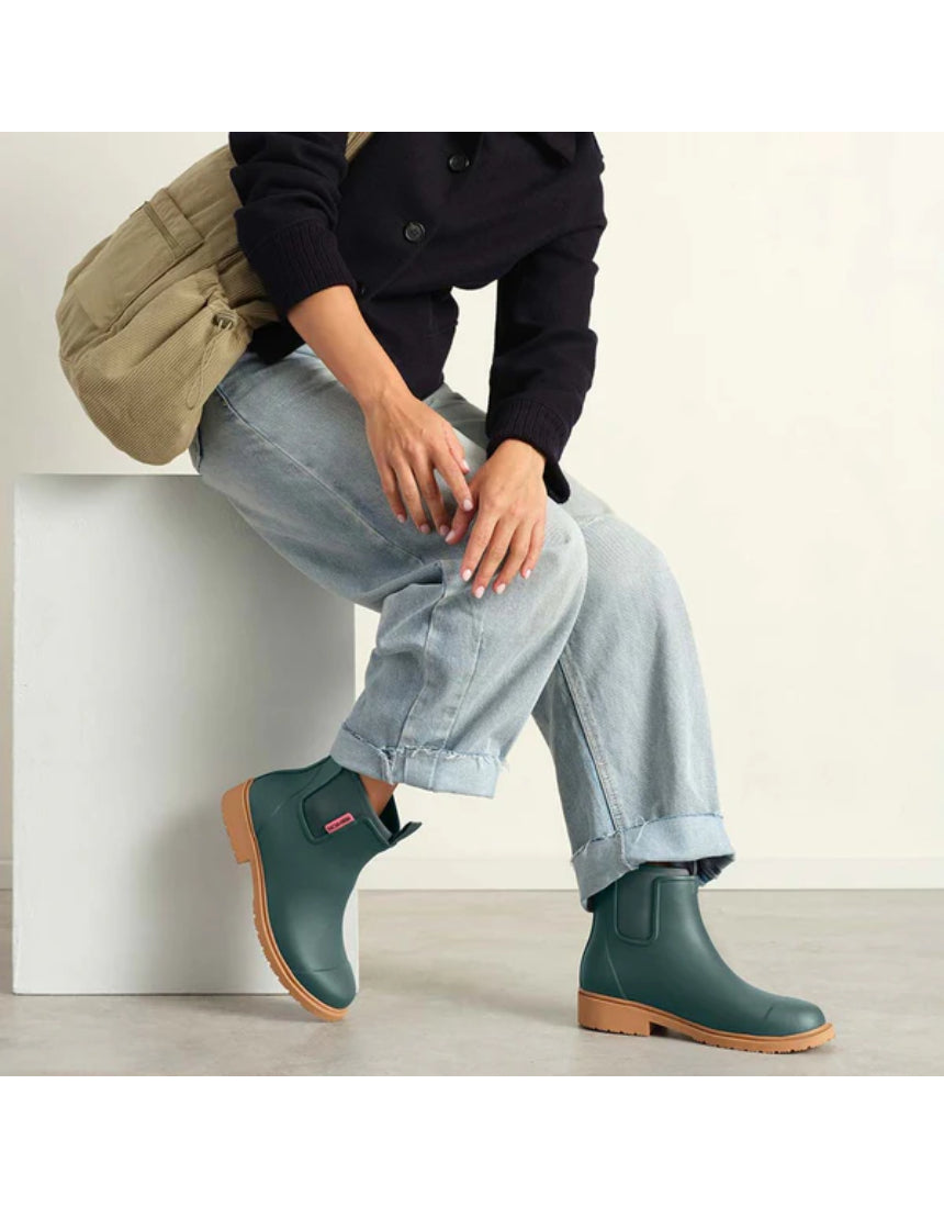 Merry People Bobbi teal gumboots worn by a model, showcasing waterproof rubber boots with a vibrant teal color and stylish design.