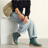 Merry People Bobbi teal gumboots worn by a model, showcasing waterproof rubber boots with a vibrant teal color and stylish design.