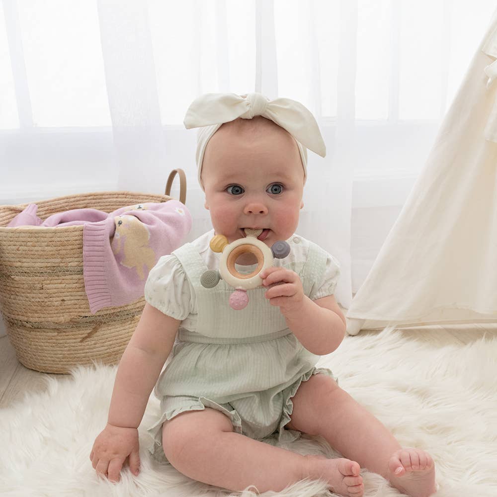 Living Textiles multi-surface teething wheel in rose color, featuring textured surfaces for soothing and chewing comfort for babies.