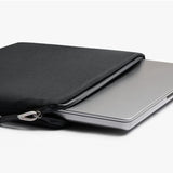 Black Bellroy Lite 16-inch laptop sleeve with smooth exterior and padded interior, designed for slim and secure laptop protection.