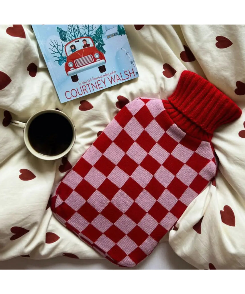 Casa Rolio blush hot water bottle with soft cover, designed for warmth and comfort, shown with the bottle inside a cozy cover.
