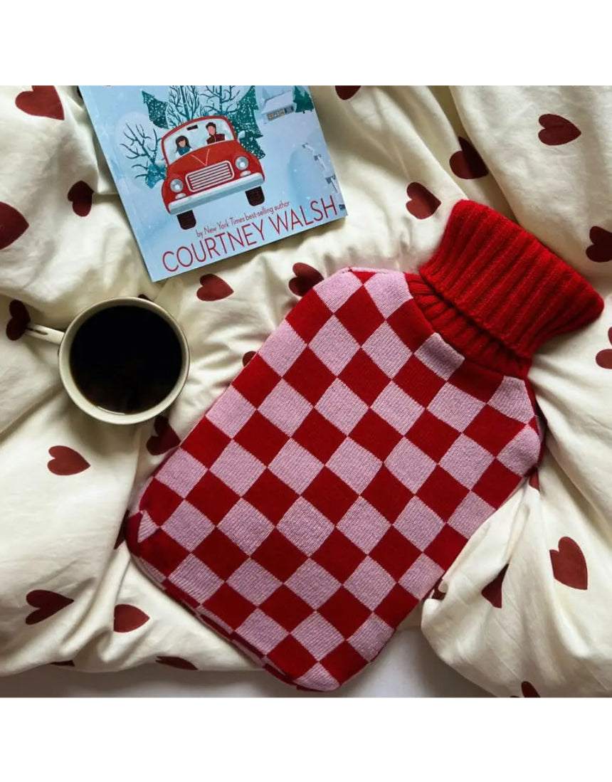 Casa Rolio blush hot water bottle with soft cover, designed for warmth and comfort, shown with the bottle inside a cozy cover.