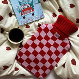 Casa Rolio blush hot water bottle with soft cover, designed for warmth and comfort, shown with the bottle inside a cozy cover.