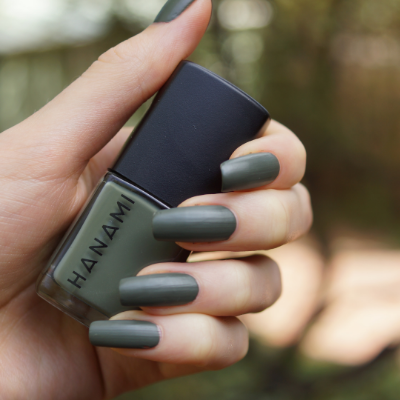 Hanami Cosmetics Hanami Moss nail polish bottle with greenish moss-colored nail polish on the brush
