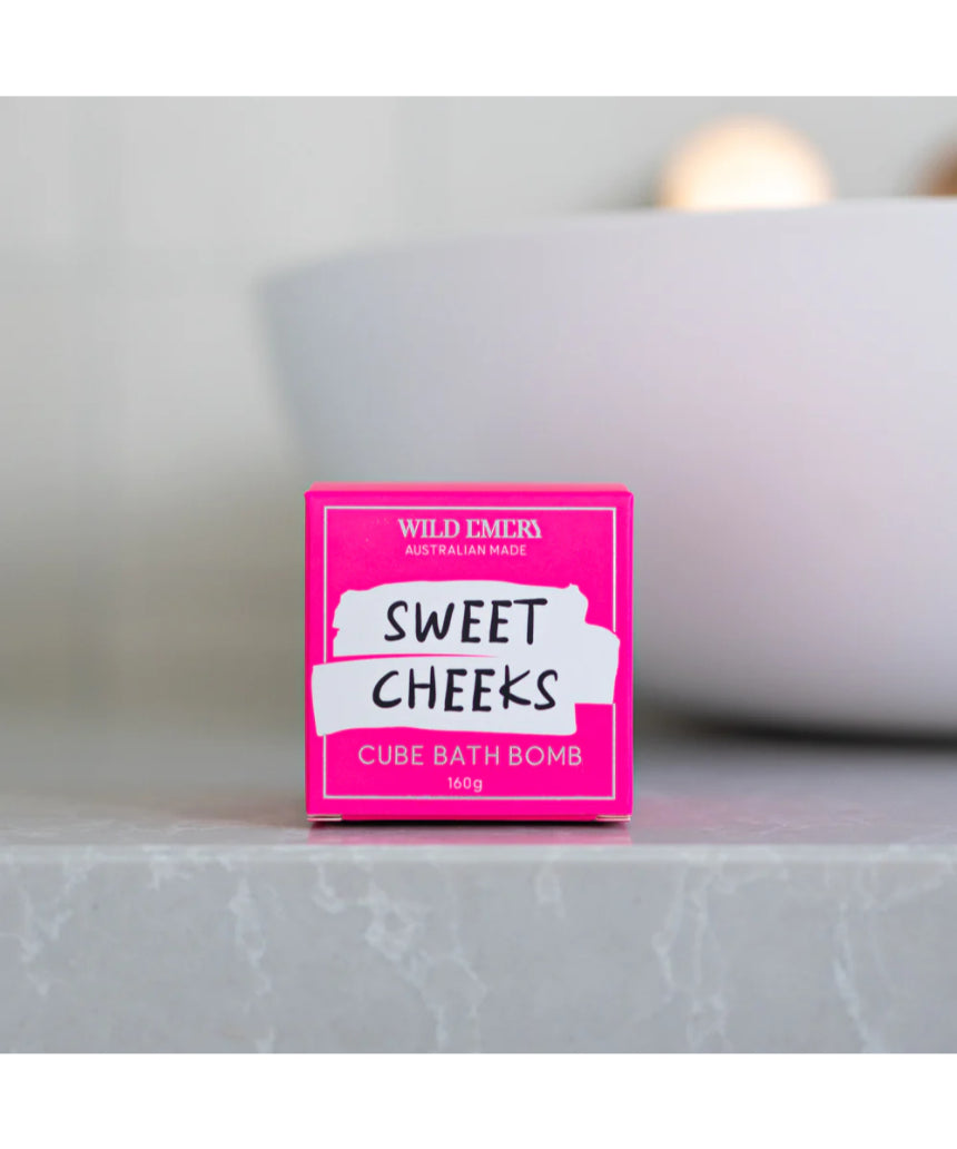 Wild Emery Sweet Cheeks Bath Bomb in vibrant pink and purple colors, designed for a relaxing bath experience.