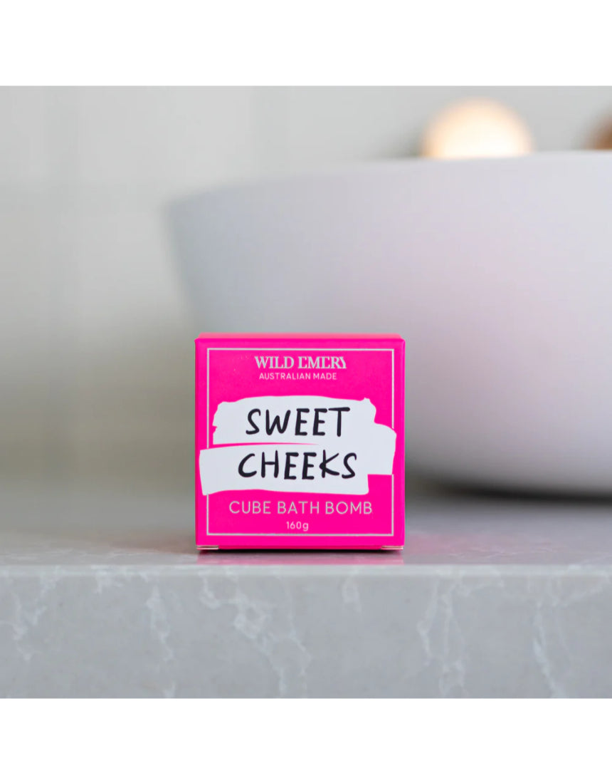 Wild Emery Sweet Cheeks Bath Bomb in vibrant pink and purple colors, designed for a relaxing bath experience.