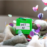 Wild Emery Wet AF Bath Bomb in vibrant colors, showing a round, fizzing bath bomb with a bold, playful design for bath & body use.