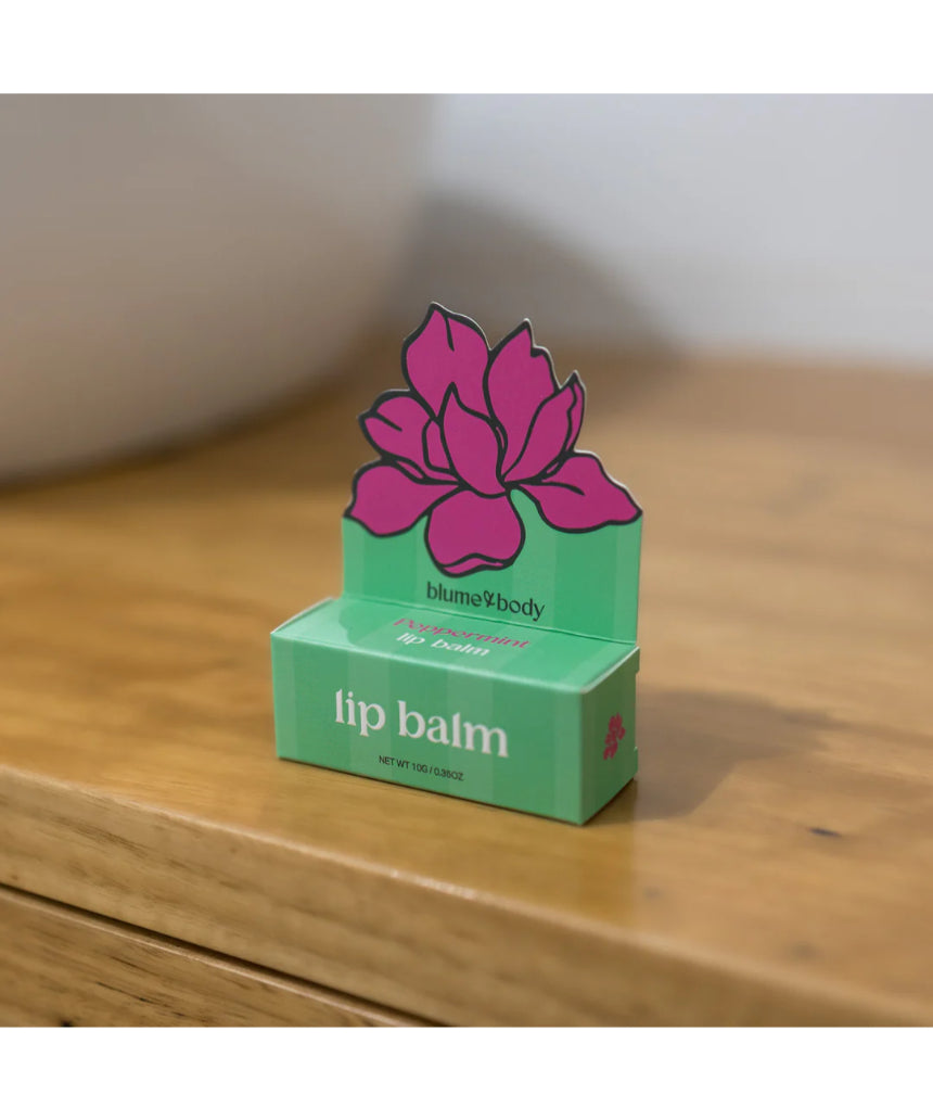 Bloom & Body peppermint lip balm tube with clear packaging and mint-green label, showing the product name and branding.