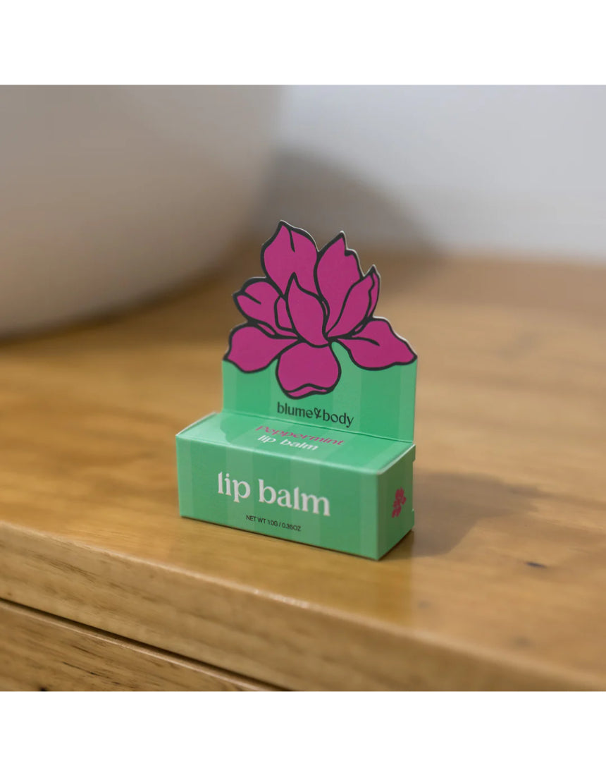 Bloom & Body peppermint lip balm tube with clear packaging and mint-green label, showing the product name and branding.