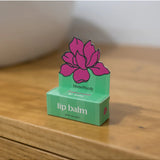 Bloom & Body peppermint lip balm tube with clear packaging and mint-green label, showing the product name and branding.