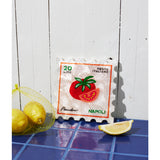 Jones & Co Pomodoro Stamp wall decor featuring a vintage-inspired red and white design on a wooden background.