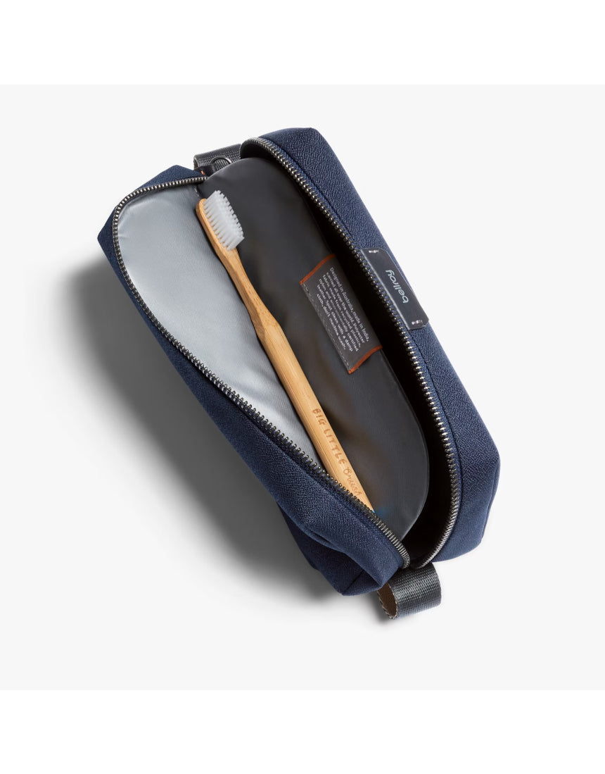 Bellroy navy toiletry kit with zipper and multiple compartments, designed for organized travel storage.