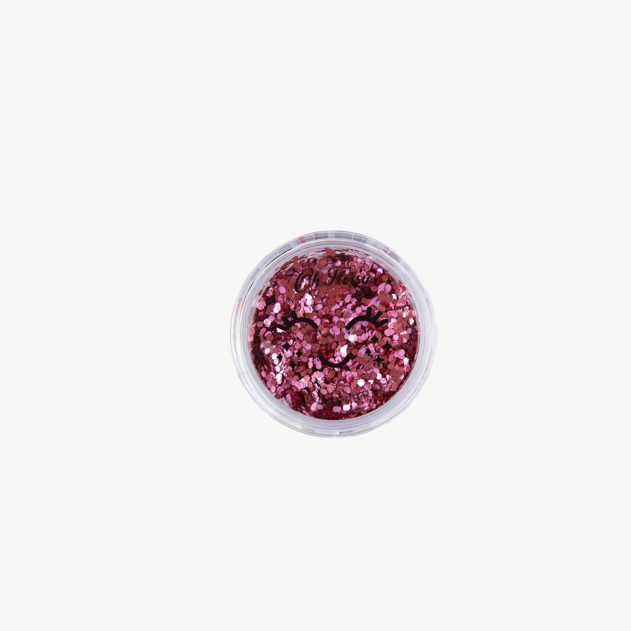 Oh Flossy biodegradable pink glitter mix in a clear container, showcasing sparkling, eco-friendly glitter for craft and beauty uses.