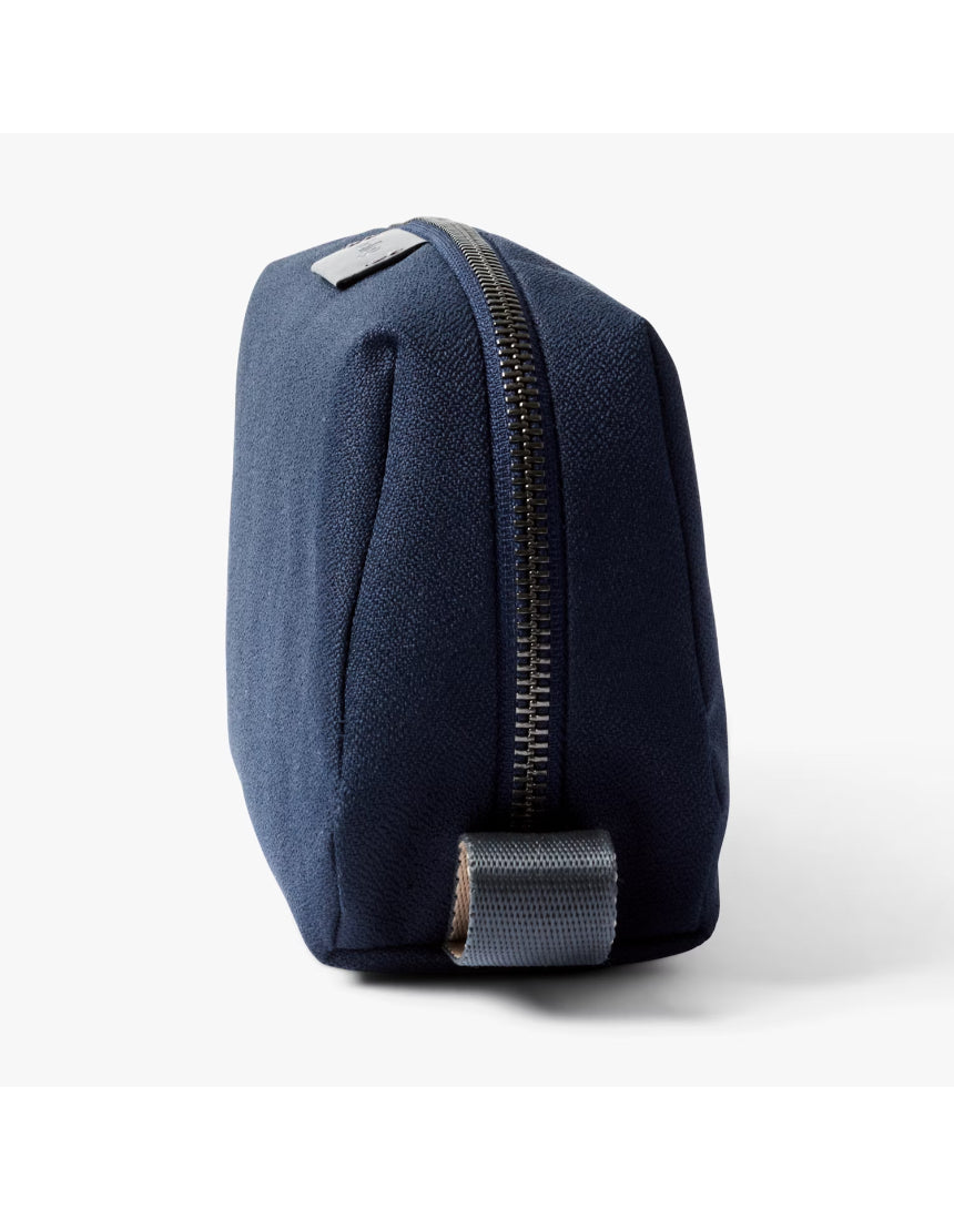 Bellroy navy toiletry kit with zipper closure, compact design, and multiple compartments for travel essentials.
