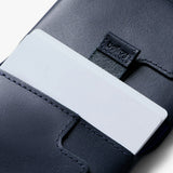 Bellroy Slim Sleeve wallet in navy color, featuring a sleek leather design with multiple card slots and a slim profile.