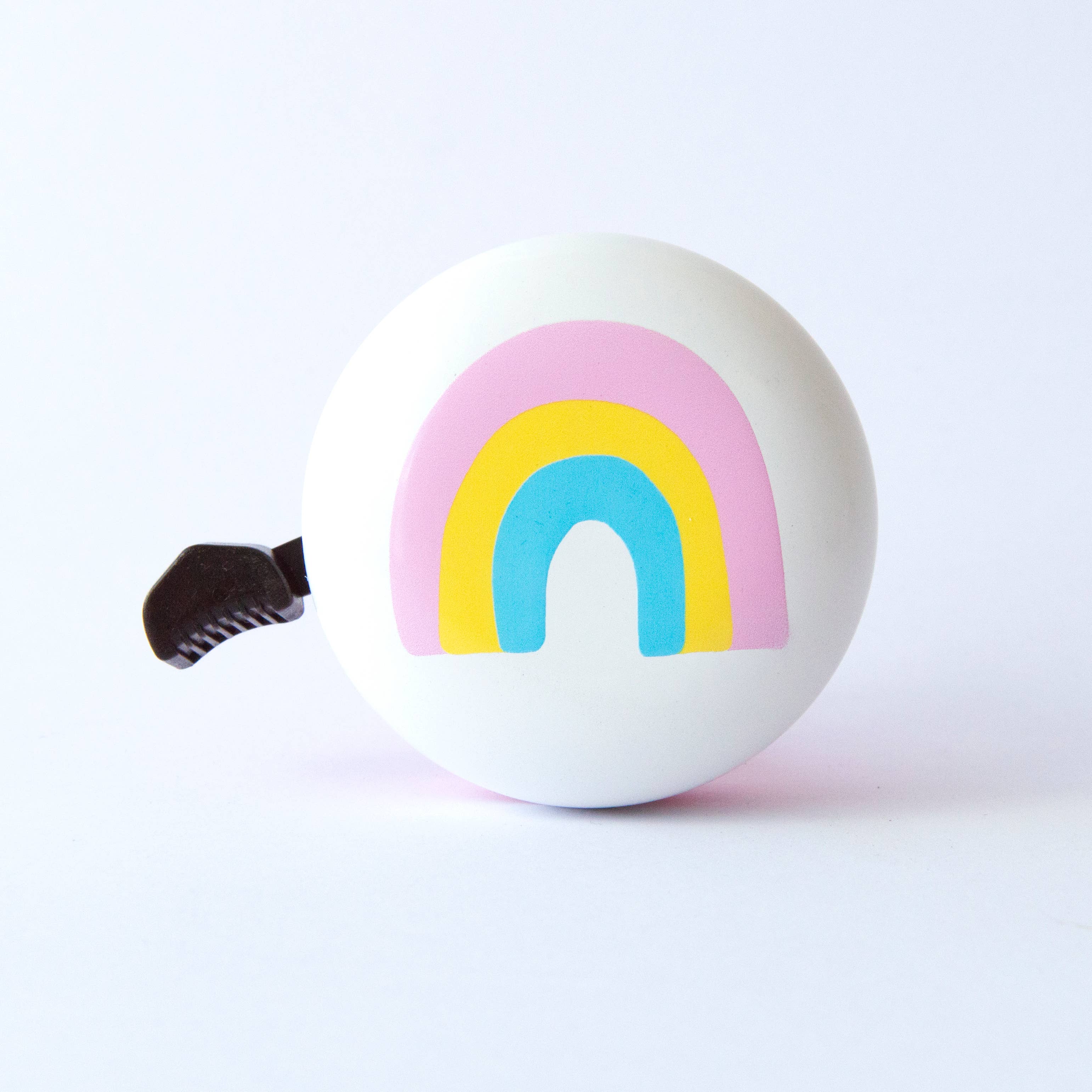 Beep Happy Rainbow Bike & Scooter Bell in white and pink with colorful rainbow design, mounted on a bicycle handlebar.