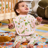 Kip & Co Sweet Daisy cotton baby bib with colorful daisy pattern, soft fabric, and adjustable neck closure.