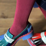 Tightology Martini Crimson Wool Tights displayed on a model, showcasing their vibrant red color and fitted style.