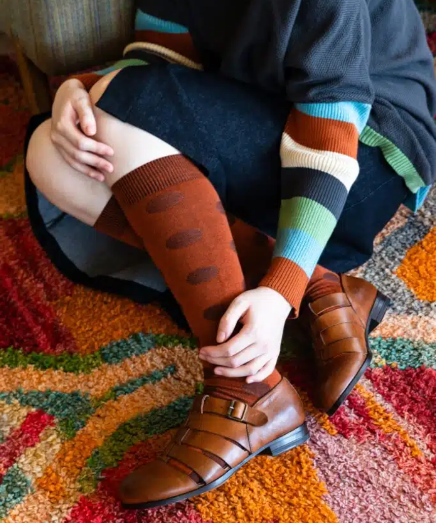 Tightology Yayoi Paprika Merino Wool Socks showing vibrant red and orange striped pattern on soft wool fabric.