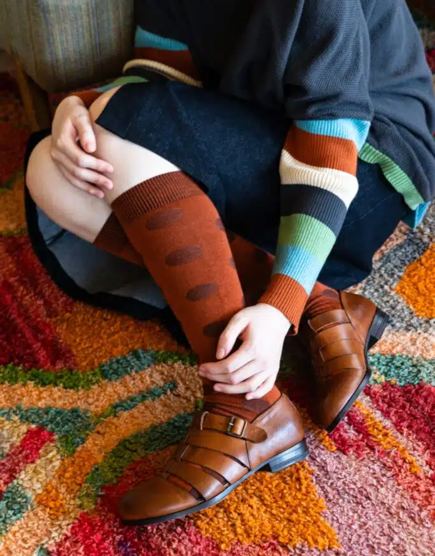 Tightology Yayoi Paprika Merino Wool Socks showing vibrant red and orange striped pattern on soft wool fabric.