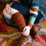 Tightology Yayoi Paprika Merino Wool Socks showing vibrant red and orange striped pattern on soft wool fabric.