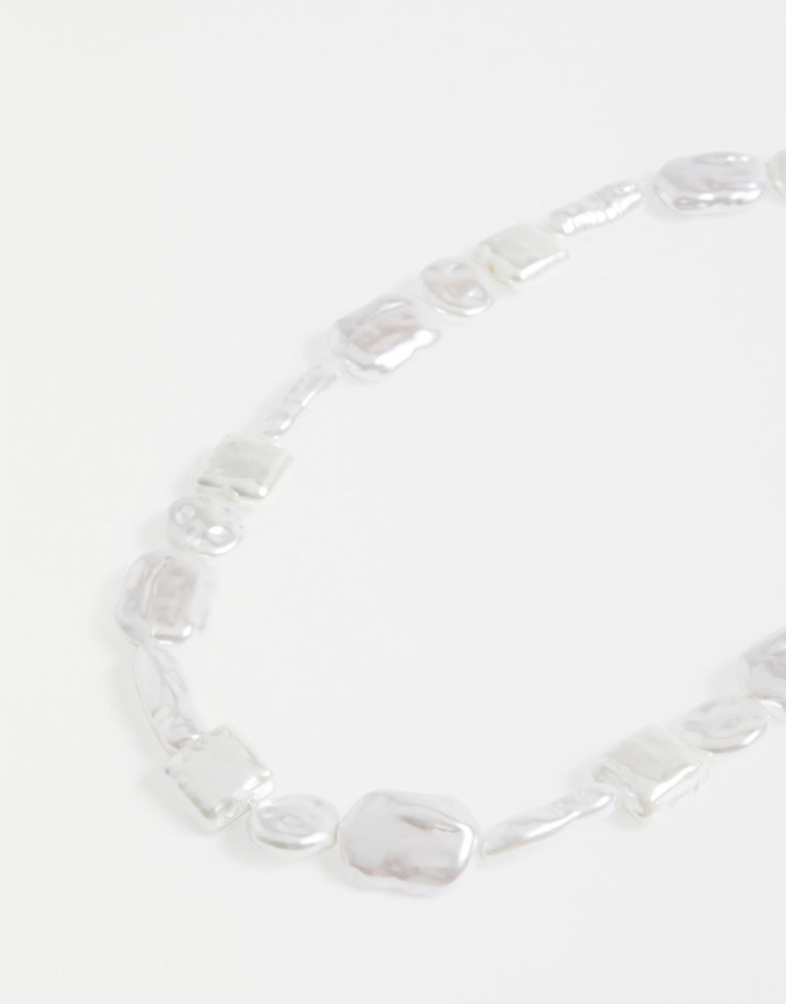 Elk Sota necklace with silver pendant featuring intricate design, displayed on a neutral background.