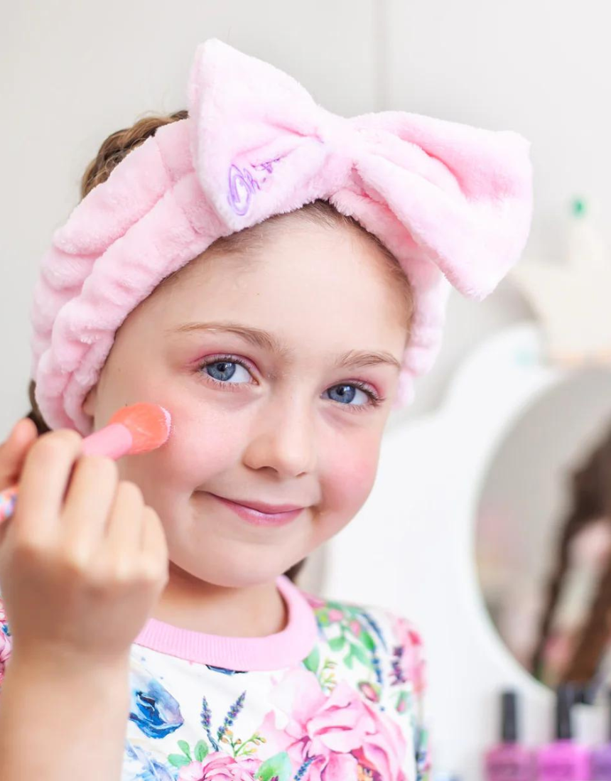 Kids' Oh Flossy cosmetic headband with pink and white polka dots, made of soft fabric for comfortable wear.