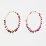 Elk Oko Hoop Earring in Mulberry color, gold-toned metal with a sleek, minimalist hoop design, close-up on a white background.
