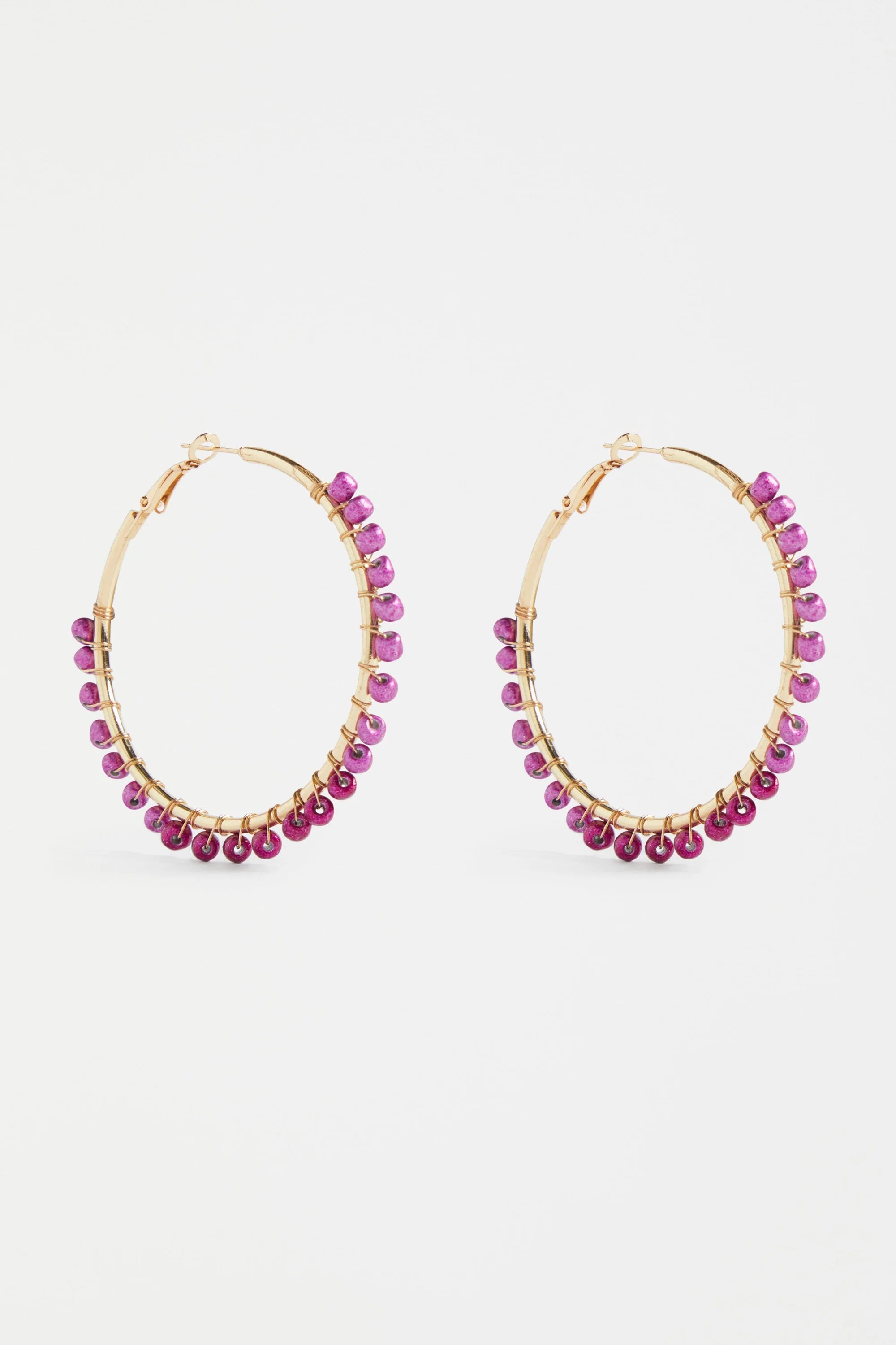 Elk Oko Hoop Earring in Mulberry color, gold-toned metal with a sleek, minimalist hoop design, close-up on a white background.