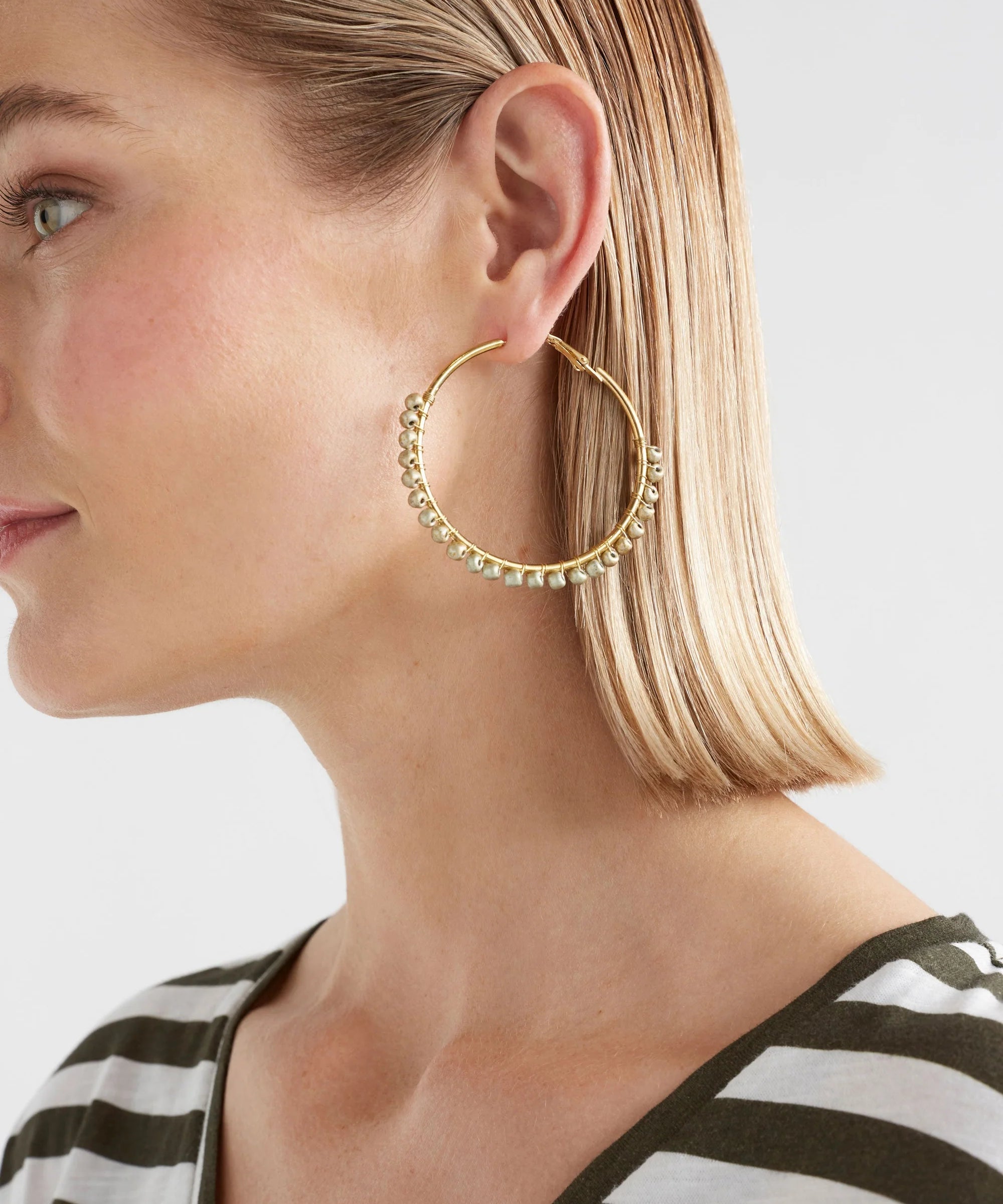 Elk Oko Hoop Earring in ecru with a textured, circular design, showcasing a stylish and modern jewelry accessory.