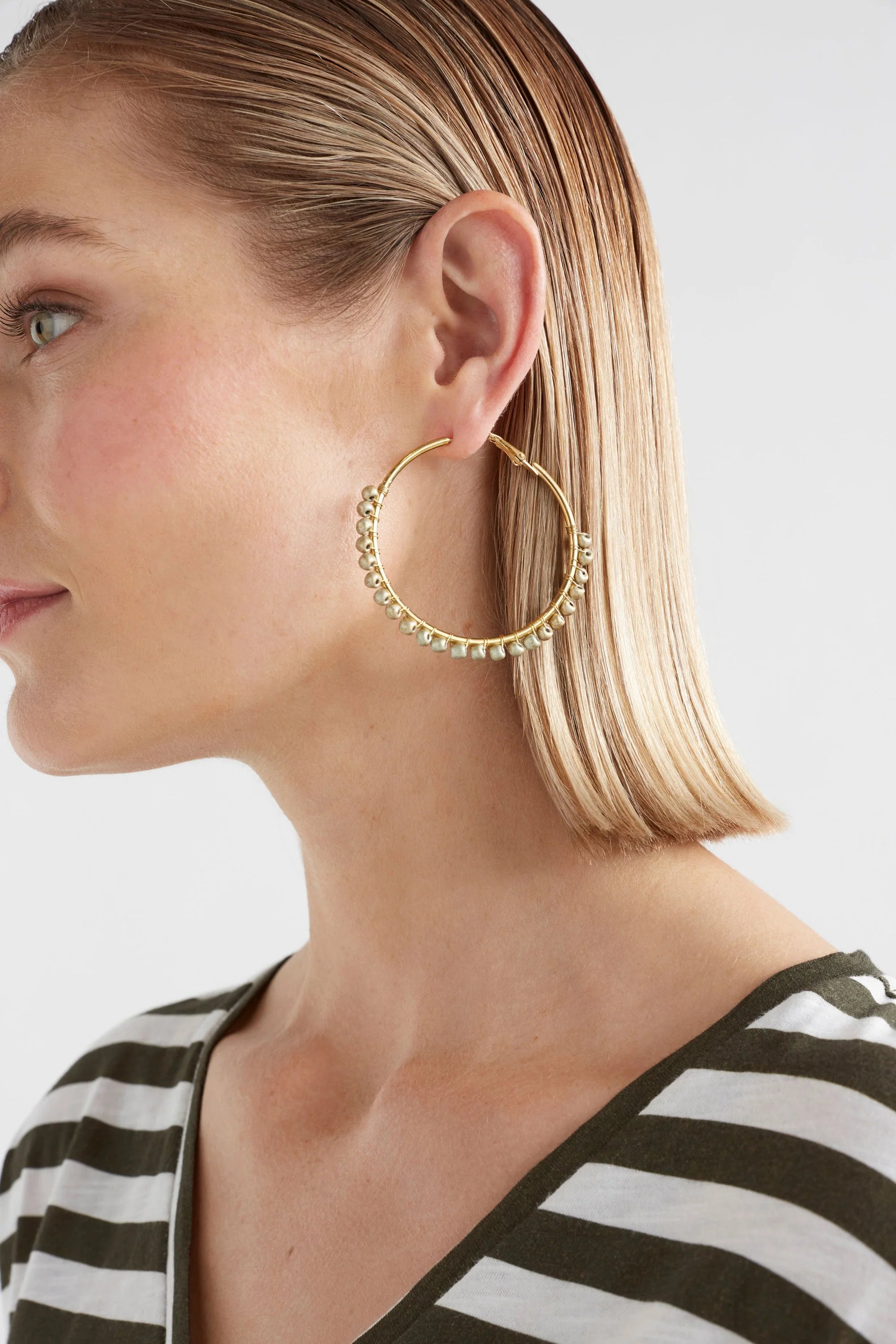 Elk Oko Hoop Earring in ecru with a textured, circular design, showcasing a stylish and modern jewelry accessory.