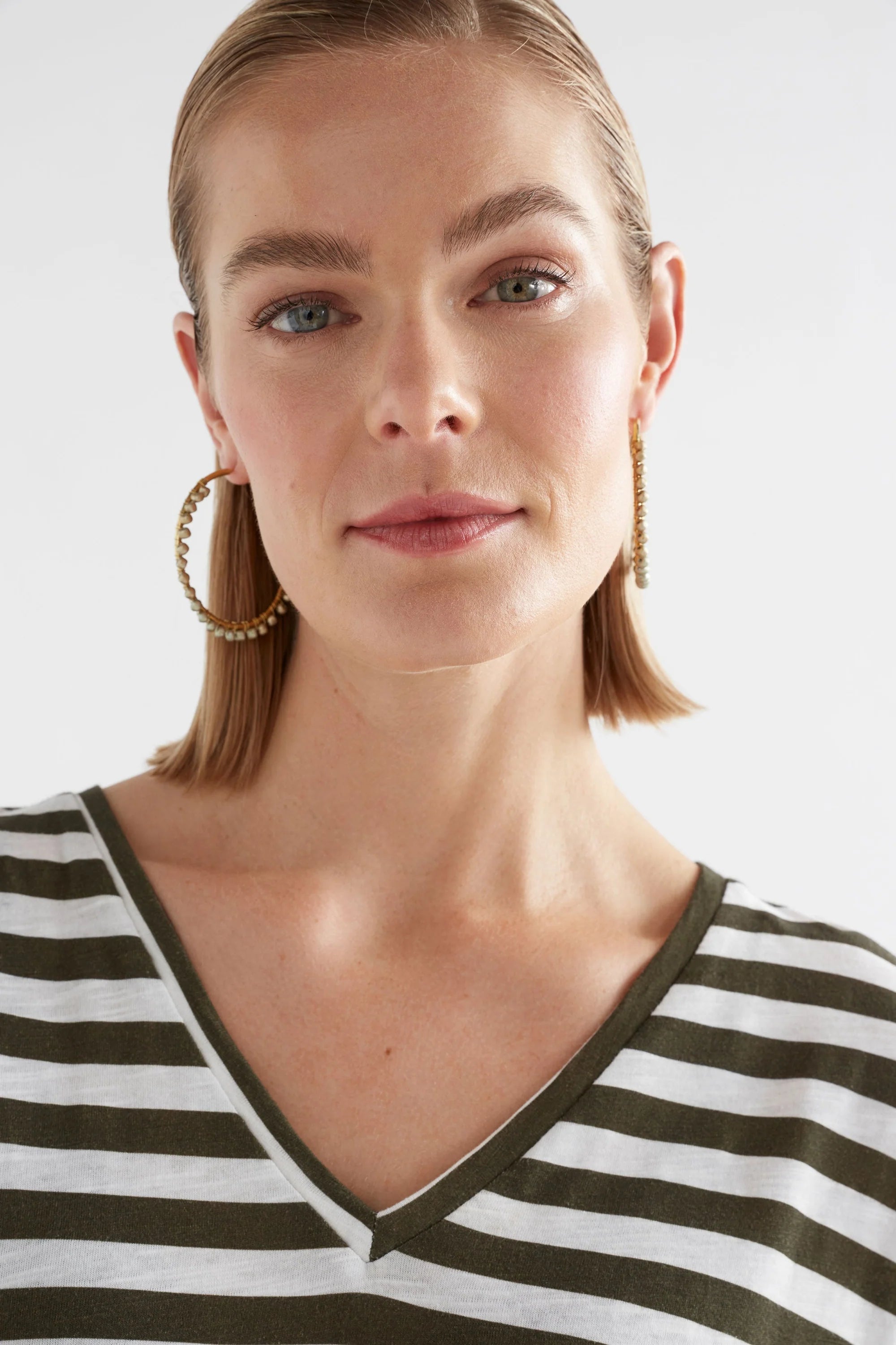 Elk Oko Hoop Earring in ecru, showcasing a sleek, minimalist design with a smooth round hoop and polished finish.