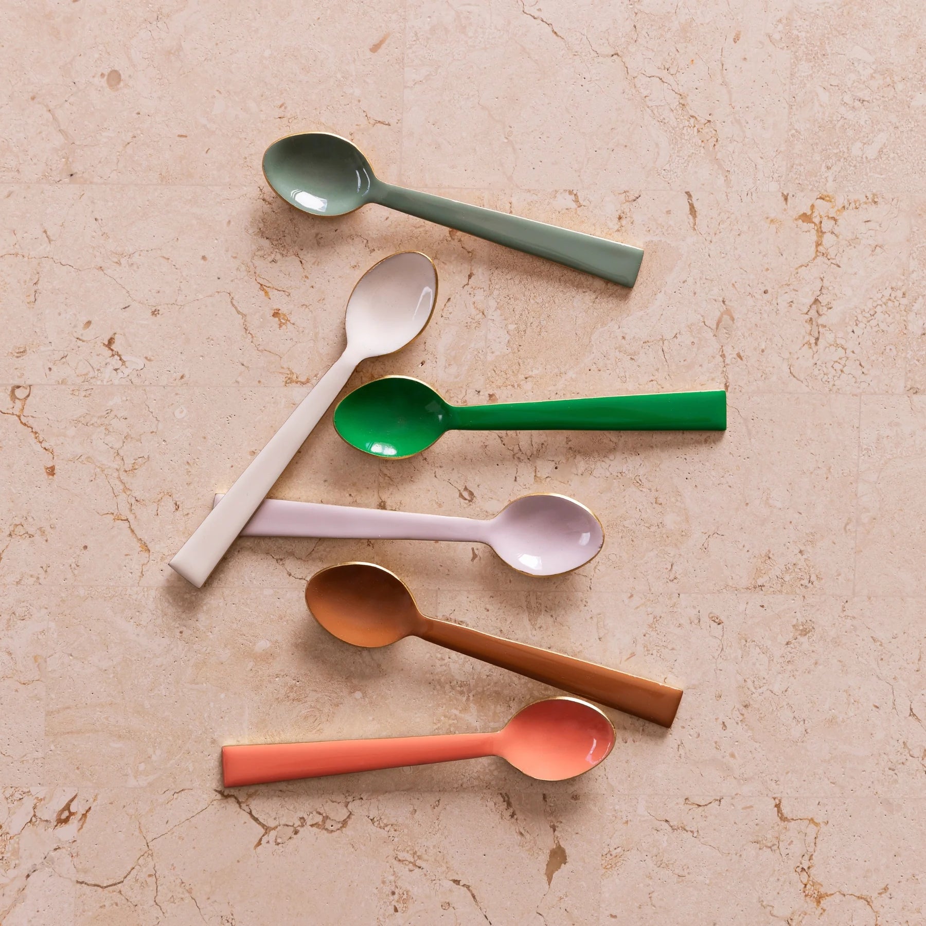 White enamel teaspoon from Bonnie and Neil's cutlery set, featuring a sleek, smooth handle design.