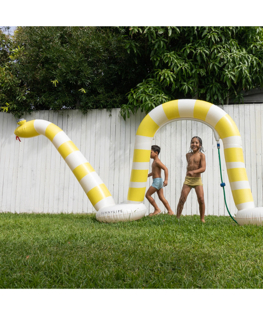 Sunnylife Snake Giant Sprinkler in vibrant colors with a winding snake design, set up outdoors for summer fun.