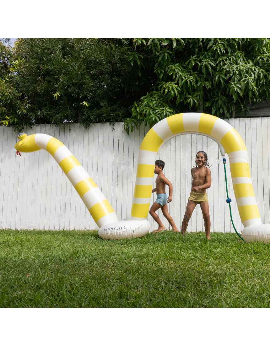 Sunnylife Snake Giant Sprinkler in vibrant colors with a winding snake design, set up outdoors for summer fun.