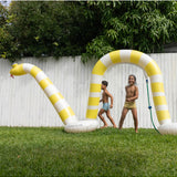 Sunnylife Snake Giant Sprinkler in vibrant colors with a winding snake design, set up outdoors for summer fun.