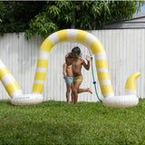 Sunnylife Snake Giant Sprinkler outdoors, colorful inflatable snake-shaped garden sprinkler with water spraying from its head.