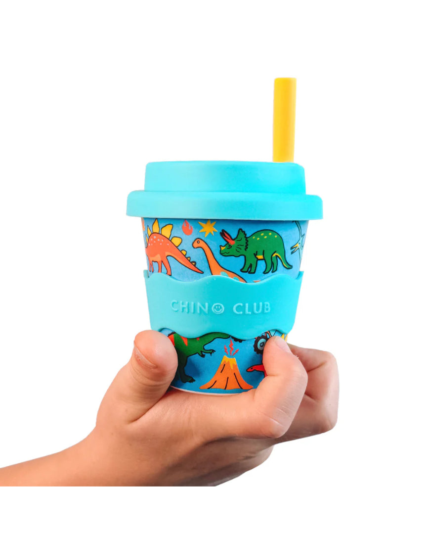 Baby Chino Cup by Chino Club featuring dinosaurs and monster trucks design, held in a child's hand, 4oz size.