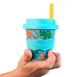 Baby Chino Cup by Chino Club featuring dinosaurs and monster trucks design, held in a child's hand, 4oz size.