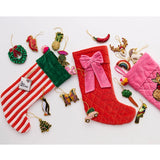 Kip & Co Christmas Bow Velvet Stocking hanging as a festive holiday decoration with red and green velvet details.
