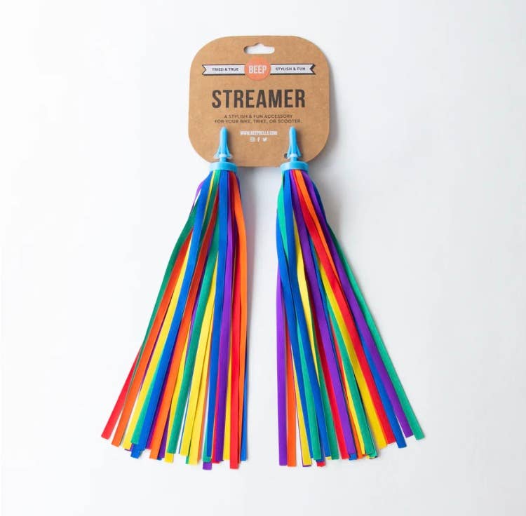 Colorful rainbow bike and scooter streamers by Beep attached to handlebars, fluttering with vibrant rainbow fabric.