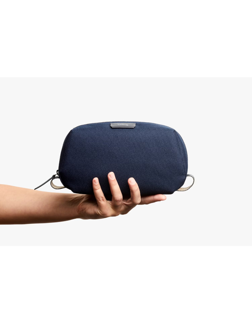 Bellroy navy toiletry kit with zippered compartments and durable nylon fabric, designed for organizing travel essentials.