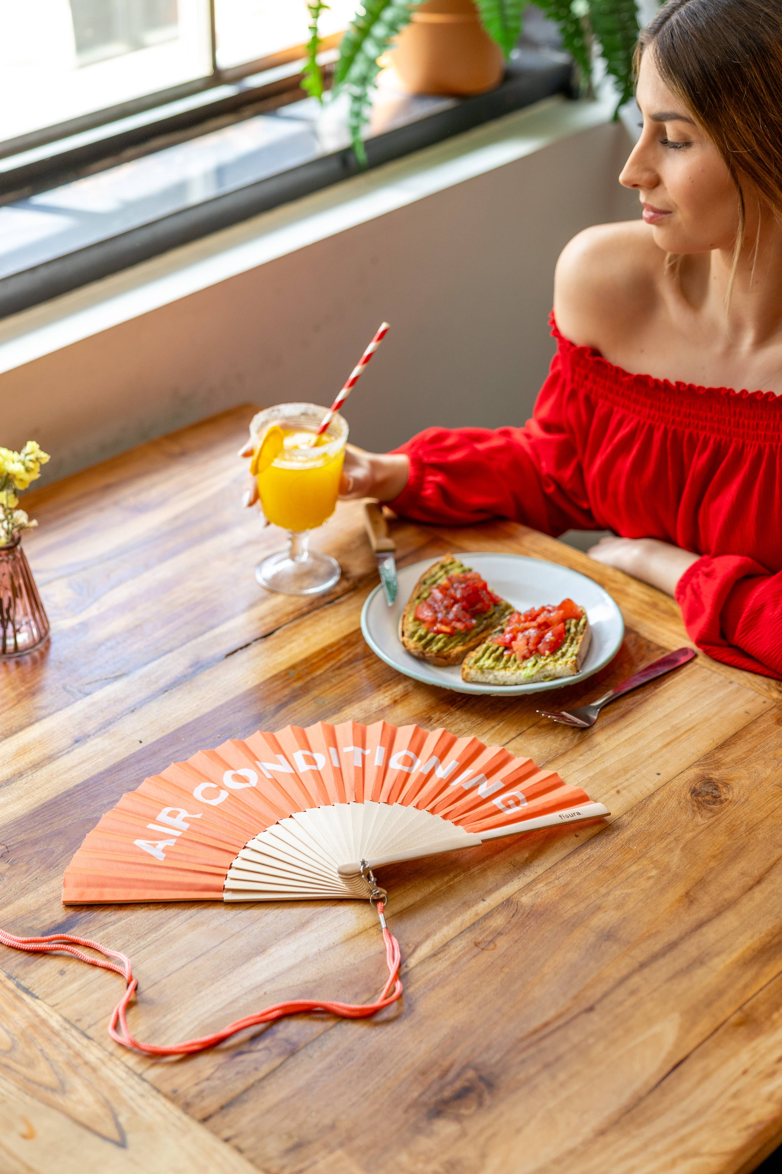 Fisura orange air conditioning fan with adjustable blades and compact design, ideal for cooling and air circulation.